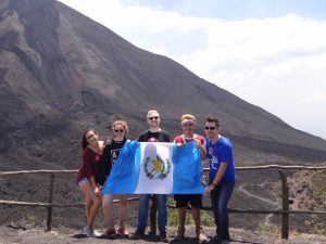 onze global volunteer deelnemer in guatemala met vlag en vrienden